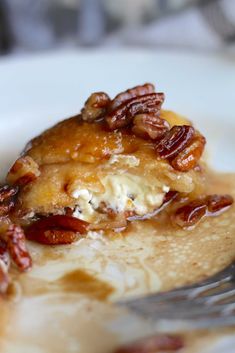 a piece of pecan pie on a plate with a fork in the foreground