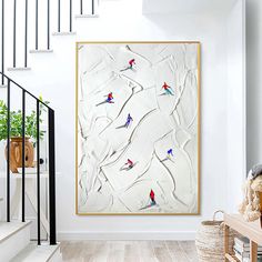 a painting hanging on the wall next to a stair case in a room with white walls and wooden floors