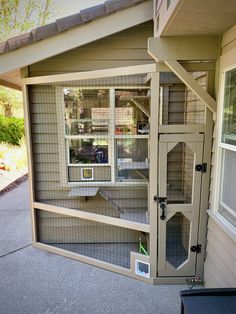 a house with an open door and some shelves in the front yard that is fenced off