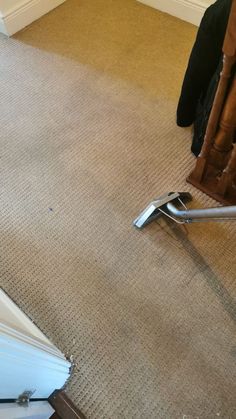 a carpet cleaning machine is on the ground in front of a doorway and stairs with a door open