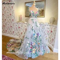 a dress on display in front of a wallpapered room with flowers and birds