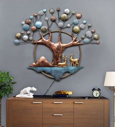 a large metal tree on the wall above a dresser with an animal figurine