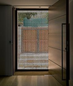 an open door in a room with wood flooring and glass doors on both sides