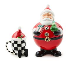 a santa clause figurine next to a black and white checkered mug