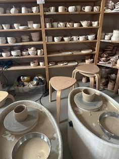 pottery is displayed on shelves in a shop