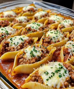 a pan filled with stuffed shells covered in sauce and cheese