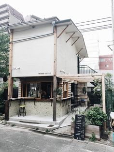 an old building with some tables and chairs on the outside, next to a street