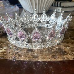 a tiara sitting on top of a table next to a vase and some books