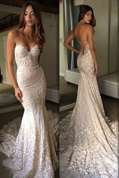 a woman in a wedding dress standing next to a mirror and looking at her reflection