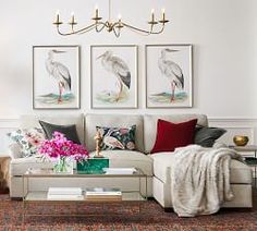 a living room filled with furniture and pictures on the wall above it's coffee table