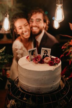 a man and woman standing next to a cake with pictures on it in front of them