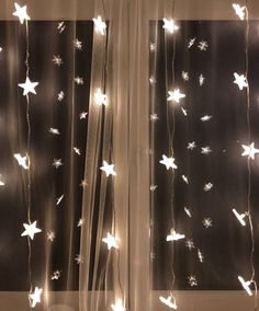 the curtain is decorated with white stars and lights on it's sheered fabric