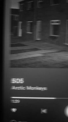 a black and white photo of an old building with the words arctic monkeys on it