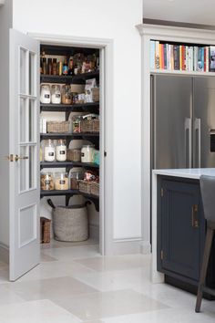 an open pantry in the middle of a kitchen next to a dining room table and chairs