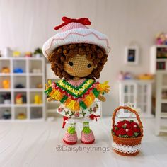 there is a small doll next to a crocheted basket and purse on the table