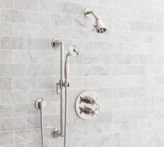 the shower head and handset are connected to the tile wall in this modern bathroom