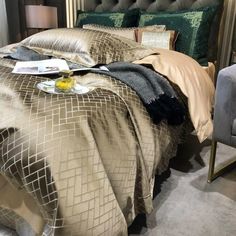 a bedroom with a bed, chair and lamp in the corner on display at an exhibit