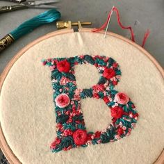 the embroidery is being worked on by someone using scissors and thread to make it look like they are in letters