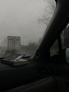 a book is sitting on the dashboard of a car in front of a semi - truck