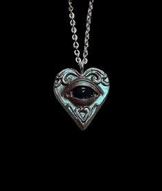 Resin pendant, measures 1 inch. This pendant is a bronze/brown color with a greenish metallic shine.  Color changing eye option: The eye is black but changes color when worn. Color will vary depending on temperature. 18 inch silver chain included. If you want the chain a specific length, leave a note when checking out. Silver Heart-shaped Copper Jewelry, Heart-shaped Silver Copper Jewelry, Mood Necklace, Heart Eye, Witchy Fashion, Nov 2, Heart Eyes, Resin Pendant, Eye Necklace