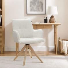 a white chair sitting on top of a wooden table next to a book shelf and lamp