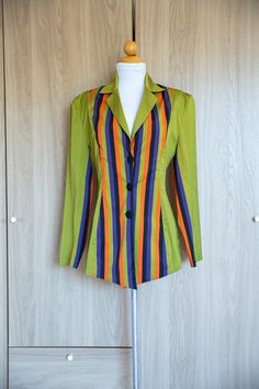 D E T A I L S * avant garde fitted 2000s lime green striped blazer  * tapered waist  * vibrant orange, purple, green and black warped vertical stripes down center of jacket and also appears on the inner sleeves * three black covered buttons * Light shoulder pads for structured look  * collared  * light weight, medium silk weave, very smooth and silky with a great sheen to it * made of silk * no label made in France A NOTE ON STYLE: Purchased this gorgeous jacket while in the French Riviera. No label but extremely well made and chic. Perfect to dress up or throw on and go casually. M E A S U R E M E N T S shoulder: 17" Sleeve: 23" waist: 14.5" length: 30" C O N D I T I O N In very good condition. Fitted Blazer With Vertical Stripes And Long Sleeves, Fitted Long Sleeve Blazer With Vertical Stripes, Fitted Vertical Stripes Spring Blazer, Spring Fitted Blazer With Vertical Stripes, Fitted Spring Blazer With Vertical Stripes, Fitted Blazer With Vertical Stripes For Spring, Purple Green Outfit, The French Riviera, Black Cover