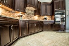 a kitchen with wooden cabinets and tile flooring