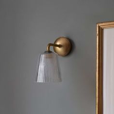 a light that is on the side of a wall next to a mirror and lamp