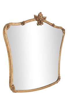 an ornate gold framed mirror with flowers on the top and bottom edge, against a white background