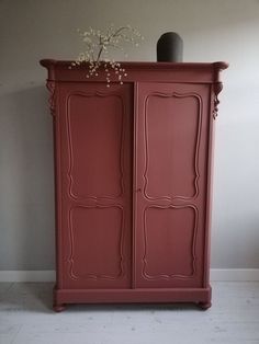 a red cabinet with flowers on top of it