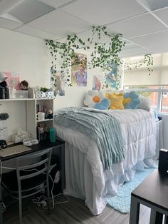 a bedroom with a bed, desk and computer