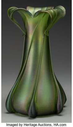 a green glass vase sitting on top of a table