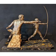 a bronze statue of two men holding an arrow and aiming at another man with a bow