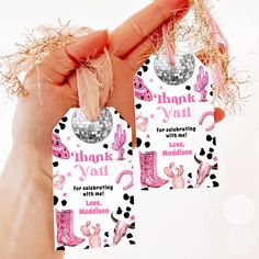 two pink and black thank you tags in someone's hand