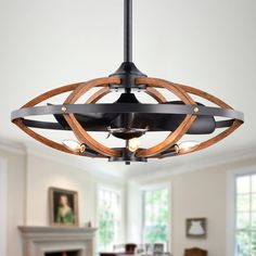 a wooden light fixture hanging from the ceiling in a room with white walls and windows