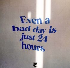 there is a sign that says even a bad day is just 24 hours on the wall