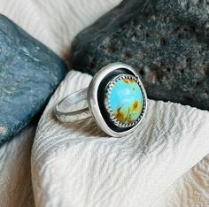 This ring features a beautifully unique bright blue piece of Kingman, AZ Turquoise. The Turquoise is set in a mini shadowbox .925 sterling silver handcrafted design and a hammered band to compliment the Boho style of the ring.  The ring is US size 6-6.25. (Just a bit larger than a true size 6.) IG: @wildrose.silver Please contact me for custom stones and sizing! Artisan One Of A Kind Turquoise Ring, Southwestern Style Blue Rings For Gift, Southwestern Style Blue Round Ring, One Of A Kind Blue Turquoise Ring, One Of A Kind Blue Sterling Silver Rings, Handmade Artisan Turquoise Ring, Oval Blue Turquoise Ring Gift, Artisan Blue Rings, Handmade Blue Turquoise Ring For Anniversary