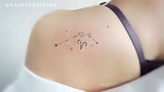 the back of a woman's shoulder with a zodiac sign tattoo on it