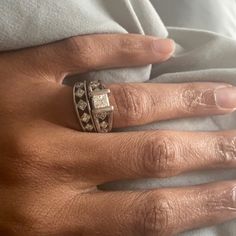 a woman's hand with a ring on it and diamonds in the middle of her fingers