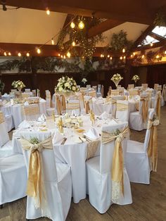 tables and chairs are set up with gold sashes, white linens, and flowers