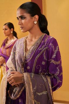 Purple silk organza A-line short kurta with vintage zardosi embroidery. Comes with pant and a slate grey dupatta. Components: 3 Pattern: Embroidered Type Of Work: Zardosi Neckline: V Neck Sleeve Type: Bell Sleeves Fabric: Silk organza Color: Purple Other Details:  Emboidered dupatta Note : Outfit worn by the model on the left is not for sale. Occasion: Mehendi and Haldi - Aza Fashions Grey Dupatta, Priyanka Singh, Zardosi Embroidery, Kurta Pant Set, Short Kurta, A Line Shorts, Kurta With Pants, Purple Silk, Silk Organza