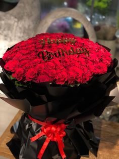 a large bouquet of red roses with the words happy birthday written on it