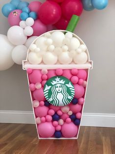 a starbucks cup filled with pink, blue and white balloons