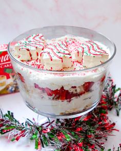 a glass bowl filled with cake and candy canes on top of a white table