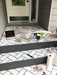 a laptop computer sitting on top of a set of steps next to a white door