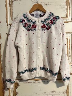 a white sweater with roses and hearts on it