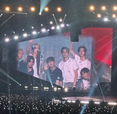 a group of young men standing on top of a stage next to each other in front of a crowd