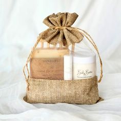 Celebrate any special occasion with our Spa Gift Bag, perfect for weddings, bridal showers, birthdays, or self-care wishes. The set includes a handcrafted soap bar, your choice of creamy body butter or soothing bath salts, all-natural vanilla lip balm, and a bamboo soap dish. Presented in a charming linen burlap and sheer organza gift bag with a drawstring, this thoughtful gift set offers a delightful spa experience, making it the perfect gift for any celebration. GIFT BAG INCLUDES: - 4.5 oz Han Spa Gift Bag, Creamy Body Butter, Vanilla Lip Balm, Labels Design, Soothing Bath, Lavender Buds, Spa Gift, Packaging Labels Design, Organic Shea Butter