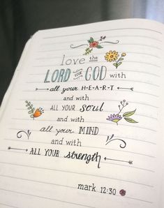 an open notebook with writing on it and flowers in the pages that says, love is god