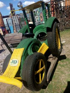 two green and yellow tractor tires sitting on top of each other in front of a building